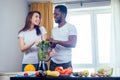 African american man with asian woman making smoothie at home Royalty Free Stock Photo