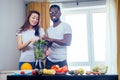 African american man with asian woman making smoothie at home Royalty Free Stock Photo