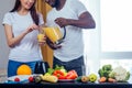 African american man with asian woman making smoothie at home Royalty Free Stock Photo