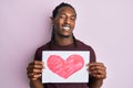 African american man with braids holding heart draw winking looking at the camera with sexy expression, cheerful and happy face