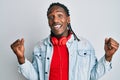 African american man with braids listening to music using headphones screaming proud, celebrating victory and success very excited Royalty Free Stock Photo