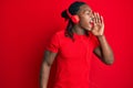 African american man with braids listening to music using headphones shouting and screaming loud to side with hand on mouth Royalty Free Stock Photo