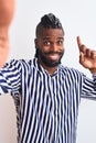 African american man with braids make selfie by camera over isolated white background surprised with an idea or question pointing Royalty Free Stock Photo