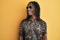 African american man with braids wearing animal print shirt and sunglasses looking to side, relax profile pose with natural face Royalty Free Stock Photo