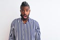 African american man with braids wearing striped shirt over isolated white background afraid and shocked with surprise expression, Royalty Free Stock Photo