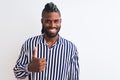 African american man with braids wearing striped shirt over isolated white background doing happy thumbs up gesture with hand Royalty Free Stock Photo