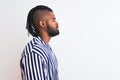 African american man with braids wearing striped shirt over isolated white background looking to side, relax profile pose with Royalty Free Stock Photo