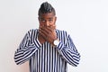 African american man with braids wearing striped shirt over isolated white background shocked covering mouth with hands for Royalty Free Stock Photo