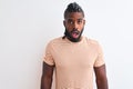 African american man with braids wearing striped t-shirt over isolated white background afraid and shocked with surprise Royalty Free Stock Photo