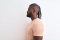 African american man with braids wearing striped t-shirt over isolated white background looking to side, relax profile pose with Royalty Free Stock Photo