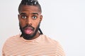 African american man with braids wearing striped t-shirt over isolated white background scared in shock with a surprise face, Royalty Free Stock Photo