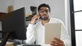 African american man business worker talking on smartphone reading notebook at office Royalty Free Stock Photo