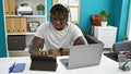 African american man business worker using touchpad and laptop working at the office Royalty Free Stock Photo