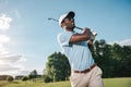 African american man in cap and sunglasses playing golf