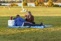 An African American man and a caucasian woman are relaxing in Gravelly Point park at a sunny afternoon.