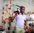 African-american man with chainsaw in gardening tools shop Royalty Free Stock Photo