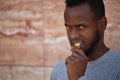 African american man chomping on a bitcoin crypto currency with his teeth in closeup Royalty Free Stock Photo