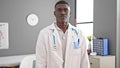 African american man doctor standing with serious expression at clinic