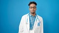 African american man doctor standing with serious expression over isolated blue background Royalty Free Stock Photo