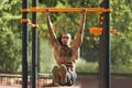 African-american man doing L-sit on horizontal bars