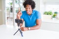 African American man doing online call with webcam using smartphone surprised with an idea or question pointing finger with happy Royalty Free Stock Photo