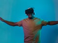 African American man dons VR glasses, engrossed in a virtual reality simulation, gesturing with hands, against a