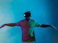 African American man dons VR glasses, engrossed in a virtual reality simulation, gesturing with hands, against a