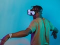 African American man dons VR glasses, engrossed in a virtual reality simulation, gesturing with hands, against a