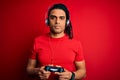 African american man with dreadlocks playing video game using joystick and headphones with a confident expression on smart face Royalty Free Stock Photo