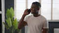 African American man ethnic cheerful young hipster guy in home bathroom talking mobile phone friendly chatting Royalty Free Stock Photo