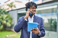 African american man executive talking on the smartphone using touchpad at park Royalty Free Stock Photo