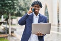 African american man executive using laptop and talking on the smartphone at park Royalty Free Stock Photo