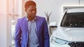 African American man explores automobile salon searching car