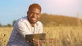 African American man explores huge wheat field smiling