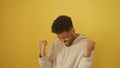 African american man expressing victory on a yellow background Royalty Free Stock Photo