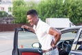 An African-American man gets out of the car. Human emotions Royalty Free Stock Photo