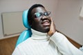 African american man having toothache sitting in a dental chair and need helping, male patient in pain. Dentistry medical