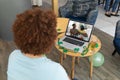 African american man having a video conference on laptop at a bar