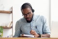 African American man in headphones taking E-learning course at office Royalty Free Stock Photo