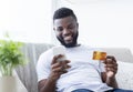 African american man holding credit card and cellphone Royalty Free Stock Photo