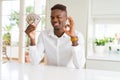 African american man holding fifty dollars bank notes doing ok sign with fingers, excellent symbol