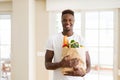 African american man holding paper bag full of fresh groceries with a happy face standing and smiling with a confident smile Royalty Free Stock Photo