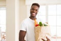 African american man holding paper bag full of groceries happy and smiling confident Royalty Free Stock Photo