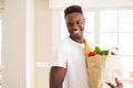 African american man holding paper bag full of groceries happy and smiling confident Royalty Free Stock Photo