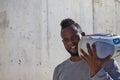 African-american man holding a radio cassette in his hands and leaning over his shoulder and listening to music Royalty Free Stock Photo