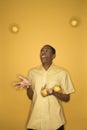 African-American man juggling lemons. Royalty Free Stock Photo