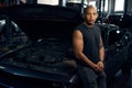 African American man leaning on car with opened hood Royalty Free Stock Photo