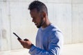 African-american man looking at his mobile phone because he has received information by text message or e-mail Royalty Free Stock Photo