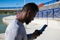 African-american man looking at his mobile phone because he has received information by text message or e-mail Royalty Free Stock Photo