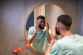 African American man looking at reflection in mirror and smiling Royalty Free Stock Photo